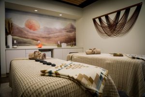 Rainwater Wellness Spa massage and treatment room stones on bed ad massage table